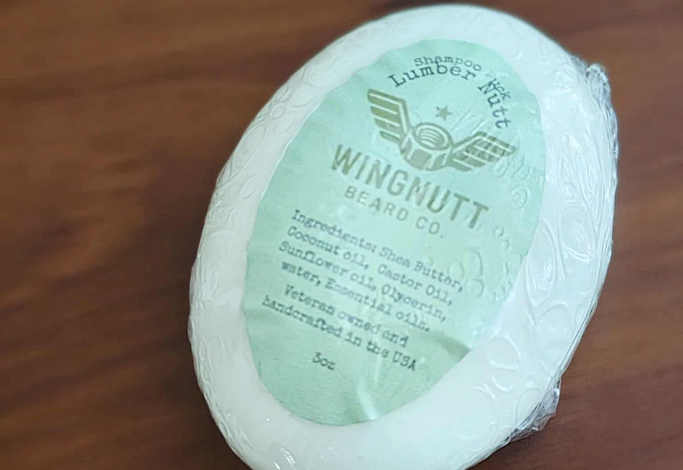 Sophisticated Nutt solid shampoo bar beside amber apothecary glassware